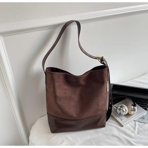 Close-up of brown suede and leather bucket bag with large capacity for commuting