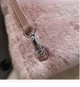 Detail of pink faux fur backpack featuring polished silver metal hooks and leather straps
