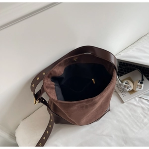 Detail shot of vintage brown suede bucket bag interior with adjustable leather strap