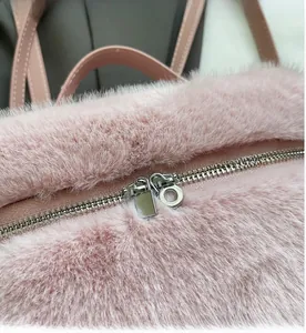 Detailed macro view of the smooth silver zipper on a pink faux fur fashion backpack