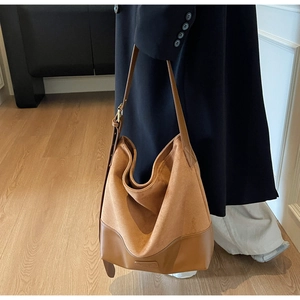 Detailed view of brown suede and smooth leather textures on a vintage hobo bag