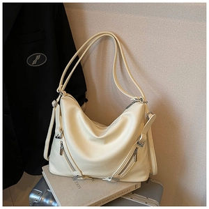 Detail of off-white lychee leather tote bag with side zippers and silver hardware