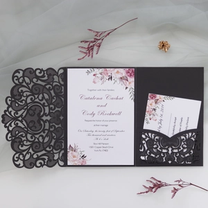 Close-up of laser-cut lace wedding invitation with elegant floral cards and stationery
