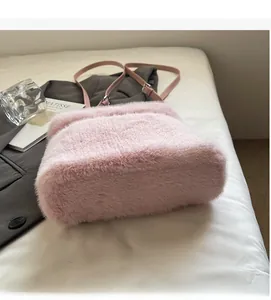 Detail of plush faux fur shoulder bag with slender pink leather strap and silver buckle