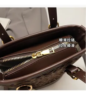 Detailed close-up of smooth gold metal zipper on a brown leopard bucket bag