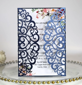 Macro view of navy blue laser-cut wedding invitation lace cover with floral inner card