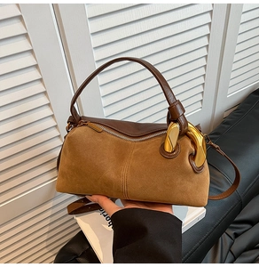 Detail of vintage brown leather pillow bag with large gold hardware buckle and handle