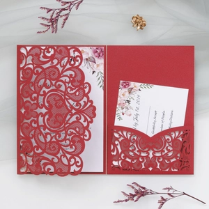 Detail of laser-cut burgundy wedding invitation with elegant floral cards and RSVP inserts