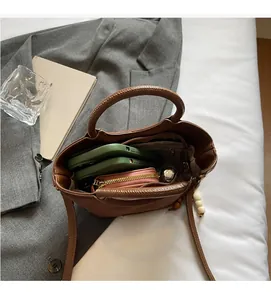 Top-down view of brown leather bucket bag interior showing capacity for two smartphones