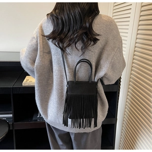 Détail d'un sac seau vintage noir à franges avec longues pampilles et poignée