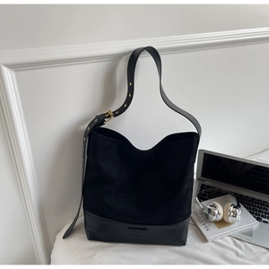 Detail of black suede hobo bag showing adjustable strap with gold eyelets and branding