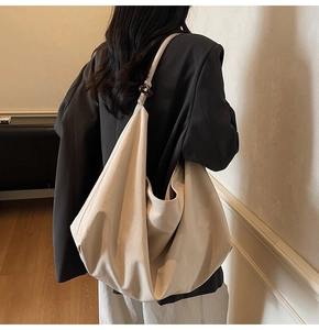 Detail of minimalist cream suede bag with tortoise shell bead accent on shoulder strap