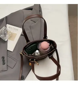 Internal view of the brown bucket bag showing capacity for phone, umbrella, and perfume