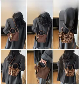 Detail view of bucket bag featuring wooden handles and leopard print or brown textures