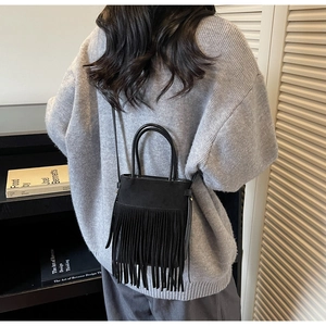 Détail du sac seau noir à franges vintage montrant la texture daim et le style bohème