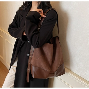 Detail of suede and leather tote bag with gold eyelet strap and vintage brown finish