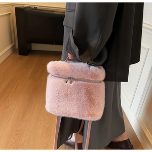 Detail view of pink plush crossbody bag with leather handle and fluffy texture