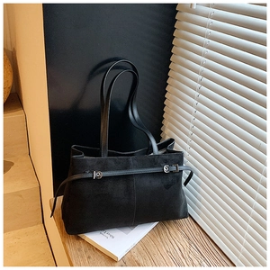 Détail du sac fourre-tout en daim noir mat avec boucle argentée et poignées en cuir lisse