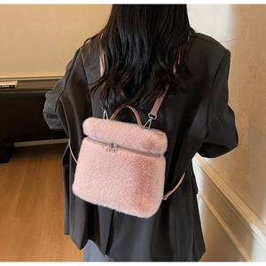 Close-up of pink faux fur backpack featuring soft plush texture and silver metal hardware