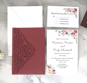 Détail d'un set d'invitations de mariage bordeaux découpé au laser avec fleurs