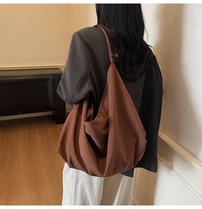 Detailed view of coffee suede hobo bag with knotted strap and soft slouchy silhouette