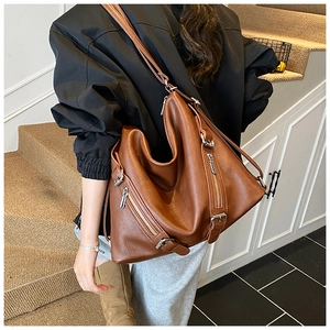 Detailed view of brown lychee grain leather tote bag with silver zipper accents
