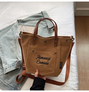 Detail view of caramel canvas tote bag with adjustable shoulder strap and logo pocket
