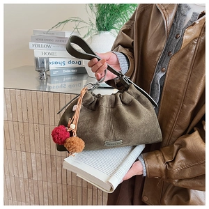 Sac seau en daim vert olive avec breloque en peluche et logo en décor vintage