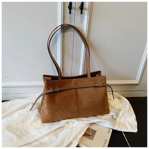 Gros plan du sac cabas en daim caramel avec fines bandoulières et boucle métallique