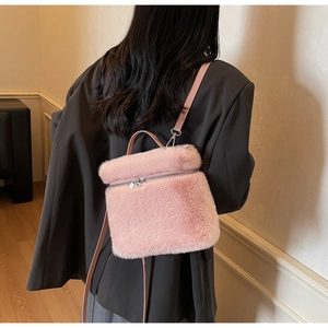 Detail of pink faux fur mini backpack with silver metal zipper and fluffy texture