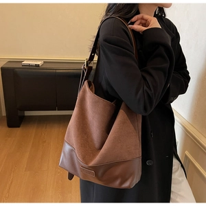 Close-up of vintage brown suede tote bag with adjustable strap and contrast stitching