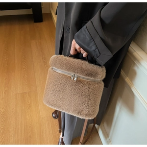 Detail of plush khaki bucket bag with premium faux fur texture and smooth metal zipper