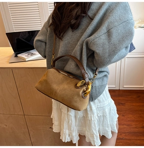 Detail of vintage Boston bag in suede and brown leather with gold metal rings