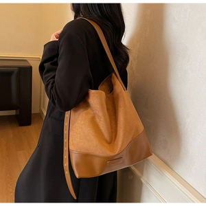 Detail of caramel suede and leather patchwork tote bag with wide eyelet shoulder strap