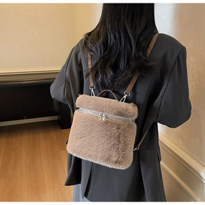 Detail view of plush brown faux fur backpack featuring silver zippers and leather straps
