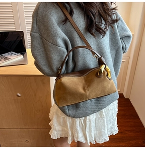 Detail view of retro suede and leather patchwork shoulder bag with gold chain hardware