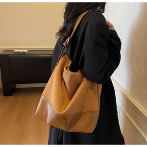 Detail of caramel suede hobo bag showing premium texture and embossed logo accents