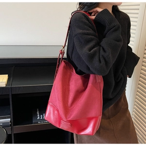 Detail of red suede patchwork tote bag showing adjustable strap and leather texture
