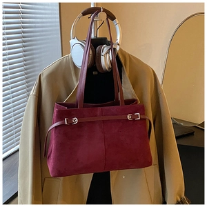 Détail du sac cabas en daim bordeaux avec boucle argentée décorative et fines lanières