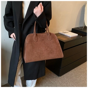 Dettaglio borsa tote trapezoidale in camoscio marrone con trama opaca vintage