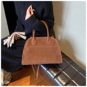 Dettaglio della borsa vintage in pelle scamosciata marrone con cuciture e trama