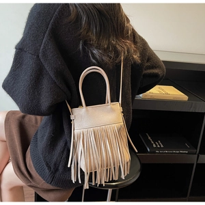Détail du sac seau vintage beige avec de longues franges et une fine bandoulière