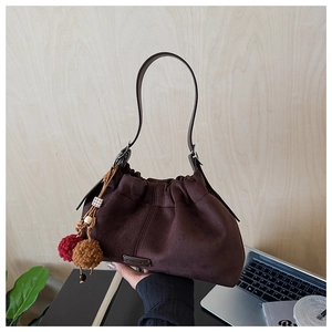 Détail du sac hobo en daim marron foncé avec cordon de serrage et breloques en peluche