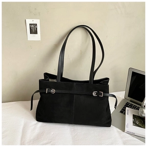 Détail du sac à bandoulière noir en daim avec sangle décorative et boucle argentée