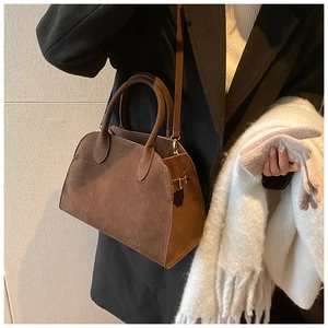 Dettaglio borsa tote in pelle scamosciata marrone con manici rotondi e fibbia in metallo