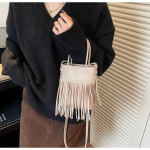 Sac seau beige à franges porté avec une tenue décontractée au style vintage