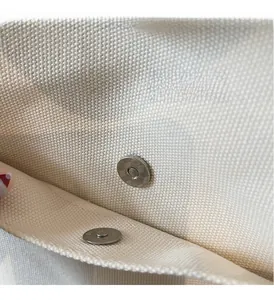 Détail du fermoir magnétique argenté sur un grand sac cabas en toile robuste
