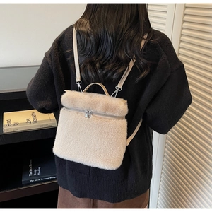 Detailed view of apricot plush backpack with faux fur texture and leather straps on model
