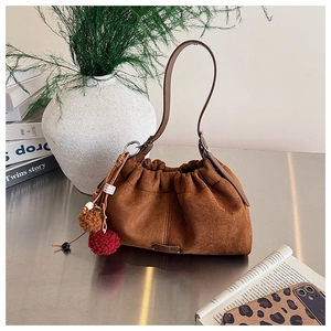 Sac hobo en daim marron avec plis souples et charms décoratifs en pompons de fourrure