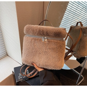 Detail view of plush brown faux fur backpack with leather handle and silver metal zippers